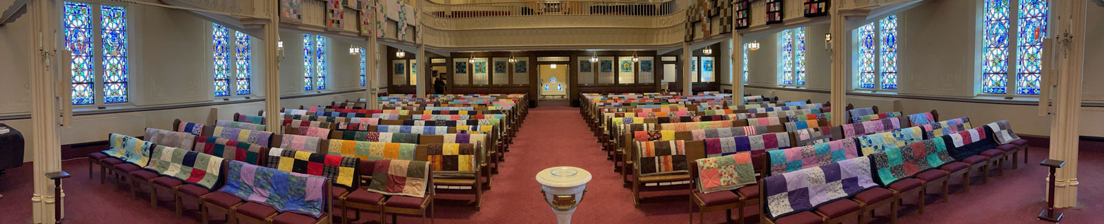 Photo of pews with quilts covering them